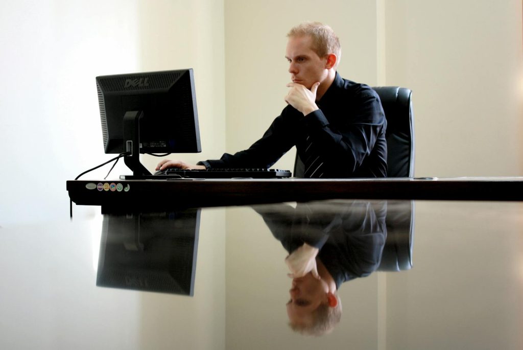 A businessman in deep thought at his desk, reflecting on work tasks.